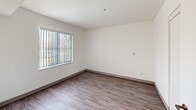 Located at 651 W 6th St in Gilroy, California, this one-bedroom, one-bathroom unit offers a thoughtfully organized single-floor layout designed to maximize every square foot. Wood-look laminate flooring runs consistently throughout the space, providing a cohesive and easy-to-maintain finish.

The galley-style kitchen is efficiently arranged with dark espresso cabinetry, light countertops, a stainless steel sink, and white appliances including a refrigerator and range. A tall pantry cabinet offers additional storage, and the kitchen opens directly toward the living area, enhancing the sense of connectivity within the unit.

The living room receives natural light through a large window fitted with vertical blinds, creating a bright and airy atmosphere. Its clean white walls and open layout provide a versatile space for various furniture arrangements.

The bedroom is a well-proportioned private retreat with its own closet and a window that brings in natural light. White walls and the same wood-look flooring continue the unit's consistent aesthetic. Two closets in total serve the unit's storage needs.

The bathroom is spacious and accessibility-friendly, featuring grab bars, a clean white finish, and generous floor space. A connecting hallway ties all rooms together in a logical and functional flow, making this unit practical for everyday living.