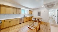 Located in Los Angeles, CA, this well-appointed 4-bedroom, 4-bathroom home offers a thoughtfully designed single-floor layout with a clean, contemporary aesthetic. Light wood flooring runs throughout, complementing the bright white walls and recessed lighting that create an airy, modern atmosphere.

The kitchen is a standout feature, showcasing natural wood shaker cabinetry with matte black hardware, crisp white quartz countertops, a marble-style backsplash, and a full suite of stainless steel appliances including a gas range, refrigerator, and dishwasher. An adjacent dining and living area benefits from natural light through a large window, making it an inviting shared space.

Each of the four bedrooms is efficiently laid out, with natural light provided by individual windows. Select bedrooms include built-in wardrobes and integrated desk areas, offering practical storage and workspace solutions. Two closets serve additional storage needs throughout the home.

All four bathrooms are finished consistently with large-format marble-look tile in the walk-in showers, white hexagonal mosaic shower floors, and matte black fixtures, delivering a polished, upscale look. A bright hallway connects the bedrooms and common areas, maintaining a cohesive flow throughout the home.
