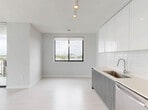 Located at 150 S Bryan Rd in Dania Beach, Florida, this three-bedroom, two-bathroom residence offers a well-designed single-floor layout with a clean, contemporary aesthetic throughout. Light wood-style flooring flows seamlessly across all rooms, complemented by crisp white walls and modern finishes that create a bright, airy atmosphere.

The kitchen is a standout feature, showcasing high-gloss white upper cabinetry, wood-toned lower cabinets, a subway tile backsplash, light quartz countertops, and a full suite of stainless steel appliances including a range, microwave, dishwasher, and French door refrigerator. Track lighting overhead adds a modern touch. The kitchen opens directly to a hallway and living area, promoting an open, connected feel.

Each of the three bedrooms is well-proportioned and filled with natural light through large windows framing expansive views of the Dania Beach skyline and lush treetops. The bedrooms feature double-door closets with sleek black hardware, adding a refined contrast to the otherwise all-white palette.

The two bathrooms are finished with neutral tile, modern vanities with wood-toned cabinetry, and a tub-shower combination with tile surround. Clean lines and recessed lighting maintain the contemporary feel throughout. Two hallways connect the rooms efficiently, and a dedicated closet provides additional storage.