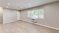 Located at 70 Mitchell Rd in Hackettstown, NJ, this two-story, one-bedroom, one-bathroom unit offers a well-planned layout spread across two levels. The main living floor features an open-concept kitchen and living room finished with light wood-tone flooring and recessed lighting. The kitchen is equipped with white shaker-style cabinetry, granite countertops, a full suite of stainless steel appliances including a gas range, over-the-range microwave, dishwasher, and refrigerator, along with a convenient breakfast bar that connects the kitchen to the living area. Large windows allow natural light to fill the space and offer views of the surrounding greenery. The living area is served by a wall-mounted AC unit and baseboard heating. The spacious primary bedroom features plush carpeting, a ceiling fan, a window with natural light, and its own wall AC unit, creating a comfortable retreat. A dedicated closet provides additional storage. The full bathroom is well-appointed with tile flooring, large-format wall tile in the shower/tub surround, and a clean white vanity. A staircase connects the two levels, completing this efficiently designed and thoughtfully updated unit.