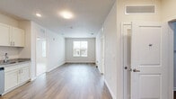 Located at 3225 W Colonial Dr in Orlando, FL, this single-floor, 2-bedroom, 3-bathroom residence offers a clean, modern aesthetic throughout. The open living area features wood-look plank flooring and a neutral color palette, creating a bright and welcoming atmosphere with natural light filtering in through the windows. The kitchen is well-equipped with stainless steel appliances — including a refrigerator, range, microwave, and dishwasher — complemented by crisp white shaker cabinetry, granite-look countertops, and a deep sink. The bedrooms are carpeted for comfort, each fitted with ceiling fans and ample closet space. The primary bedroom includes a spacious walk-in closet with wire shelving systems for organized storage, along with its own private bathroom. The bathrooms are finished with granite-topped vanities, wood-look flooring, and tiled shower enclosures, lending a polished look. A dedicated closet provides additional storage convenience. The overall design emphasizes functionality and modern simplicity, with consistent finishes tying together each room for a cohesive living experience.