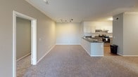Located at 4795 Frazee in Oceanside, unit 1512 is a single-floor residence thoughtfully designed with a clean, modern aesthetic throughout. The open-concept layout connects the kitchen and living area seamlessly, creating a spacious, functional flow ideal for everyday living and entertaining.

The kitchen is well-appointed with white shaker-style cabinetry, dark granite-style countertops, and a peninsula that extends into the living space, offering additional prep and seating space. Stainless steel appliances — including an electric range, built-in microwave, and dishwasher — complement the kitchen's contemporary finish. Wood-style flooring runs through the kitchen, contrasting with the plush carpeting found throughout the living area and bedrooms.

The living room is generously proportioned, featuring crown molding, neutral gray walls, and track lighting that adds a modern touch. Natural light filters in through windows fitted with blinds.

The bedrooms are comfortably sized with soft carpeting, neutral tones, and windows that allow natural light. Six-panel white doors are consistent throughout the unit, adding a classic detail to the interior.

The bathroom includes a combination tub and shower, wood-style flooring, and clean white fixtures, providing a functional and tidy space. Overall, the unit presents a cohesive, well-maintained interior suited for comfortable residential living.