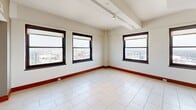 Located in the heart of Detroit at 10 Witherell St, this two-bedroom, two-bathroom residence is spread across two floors, offering a well-designed layout that balances open living areas with private retreats. The main floor features a welcoming entrance with light tile flooring that flows through the hallway and into the open-plan kitchen, dining, and living area. The kitchen is a standout, equipped with warm wood cabinetry, dark granite countertops, a large island with a stainless steel sink, mosaic tile backsplash, and a full suite of stainless steel appliances, all illuminated by contemporary pendant and track lighting. A secondary bathroom on this level offers a clean, minimalist design with a floating vanity and tile flooring. A dramatic wrought iron spiral staircase serves as a bold architectural centerpiece, connecting the floors in style. Upstairs, both bedrooms feature plush carpeting and large dark-framed windows that frame sweeping views of the Detroit cityscape. The spacious primary bedroom includes generous closet space. The primary bathroom offers a soaking tub with granite surround, a glass-enclosed shower, and a dark-cabinetry vanity. Carpet-lined hallways with wall sconces add warmth to the upper level.