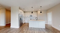 This single-story, 3-bedroom, 2-bathroom home in Jacksonville, FL offers a thoughtfully designed layout with contemporary finishes throughout. The open-concept living area is bathed in natural light from multiple large windows and features durable light wood-style flooring, a ceiling fan, and direct access to the outdoors via a rear door — creating a bright, airy atmosphere.

The kitchen is a standout feature, showcasing white shaker cabinets, a tiled subway-style backsplash, stainless steel appliances including a refrigerator, microwave, and range, and a spacious center island with a light countertop, undermount sink, and stylish matte black pendant lighting overhead.

The three bedrooms are carpeted for comfort and each include ceiling fans and windows with outdoor views. The generously sized primary bedroom features a bank of three windows and a walk-in closet outfitted with wire shelving. Both bathrooms offer clean, neutral finishes, with one featuring a tub/shower combo lined in classic white subway tile with matte black hardware accents.

A dedicated laundry area houses a full-size front-loading washer and dryer. Neutral warm-toned walls, wood-style flooring in the main areas, and consistent modern hardware create a cohesive, move-in-ready aesthetic throughout.