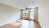 This well-appointed two-story residence at 3240 Killian St in Grand Rapids, Michigan offers three bedrooms, two bathrooms, and a thoughtfully designed layout spread across two floors. The entry level features a combined kitchen and living area bathed in natural light from large windows, with wood-look flooring throughout. The kitchen is a standout, showcasing white shaker cabinetry reaching to the ceiling, granite countertops, a central island with an undermount sink, stainless steel appliances, and a decorative patterned tile backsplash. The living area includes a ceiling fan and direct access to an outdoor balcony. Upstairs, the expansive primary bedroom offers generous proportions, plush carpeting, and a well-organized walk-in closet with built-in shelving, hanging rods, and drawer storage. The primary en-suite bathroom features a glass-enclosed subway tile shower, granite vanity, and wood-look flooring. A second full bathroom mirrors the same quality finishes, with a soaking tub, subway tile surround, and granite vanity. The additional bedrooms are bright and carpeted, each with ceiling fans and ample natural light from multiple windows. Neutral tones and modern fixtures create a clean, cohesive aesthetic throughout.
