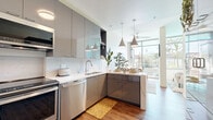 Located at 795 Third Ave in Chula Vista, CA, this modern one-bedroom, one-bathroom unit offers a well-designed layout with contemporary finishes throughout. Warm hardwood-style flooring flows seamlessly across the entire space, creating a cohesive and inviting atmosphere.

The kitchen is a standout feature, boasting high-gloss gray cabinetry — both upper and lower — paired with white quartz countertops and a classic subway tile backsplash. A full suite of stainless steel appliances includes a refrigerator, range, over-the-range microwave, and dishwasher. Stylish pendant lights hang above the peninsula, which offers additional prep and dining space. A floor-to-ceiling glass wall allows abundant natural light and provides direct access to an outdoor balcony.

The entry area includes a built-in high-gloss storage wardrobe, providing practical organization from the moment you step inside. The generously sized bedroom features a sliding-door closet with rod storage, offering ample room for clothing and personal belongings.

The bathroom is finished with elegant marble-look wall tile, a glass-enclosed walk-in shower, a white vanity with countertop sink, and warm tile flooring — delivering a clean, spa-like aesthetic.

This thoughtfully designed unit combines smart storage, modern style, and functional living in a compact yet efficient footprint.