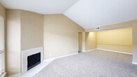 Located at 3700 Watonga Blvd in Houston, TX, this 2-bedroom, 4-bathroom single-floor residence offers a well-organized layout with a variety of functional spaces, including a living room, dining room, kitchen, pantry, hallway, and five closets. The living room is an immediate standout, featuring dramatic vaulted ceilings, a tile-surround wood-burning fireplace, and a large window that fills the space with natural light. Soft carpet flooring runs throughout the living areas and bedrooms, lending a warm, comfortable feel. The galley-style kitchen is efficiently designed with dark espresso cabinetry, granite-style countertops, a white subway tile backsplash, stainless steel appliances, and durable wood-look flooring. The primary bedroom benefits from soaring vaulted ceilings, a ceiling fan, a built-in vanity with cabinetry, and direct access to a private area with additional closet space and shelving. Secondary bedrooms and closets are well-proportioned, with multiple closets providing ample storage throughout the home. Bathrooms are clean and functional, featuring dark cabinetry with granite-style counters and tub/shower combinations. The neutral warm-beige palette and consistent finishes create a cohesive and inviting atmosphere throughout the entire home.