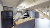 Located at 1503 D Monmouth Street in Lancaster, Ohio, this two-floor residence offers a thoughtfully updated interior with a cohesive neutral color palette throughout. The kitchen serves as a standout feature, showcasing grey shaker-style cabinetry, a mosaic tile backsplash, black appliances including a refrigerator and range, and a peninsula island with a warm butcher block countertop — ideal for casual dining or meal prep. Light wood-look vinyl flooring runs through the kitchen and living areas, adding a clean, modern feel. A decorative tray ceiling with ambient lighting adds architectural interest to the kitchen space. The bedrooms are generously sized, finished with plush grey carpeting, ceiling fans with light fixtures, baseboard heating, and windows that invite natural light. The neutral grey walls carry a calm, consistent tone across all rooms. The bathrooms are well-appointed with white cabinetry featuring brushed nickel hardware, white countertops, framed mirrors, and tub-shower combinations, all accented by the same light vinyl flooring. The overall design is clean and contemporary, making this two-story space a practical and comfortable home in Lancaster, Ohio.