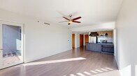 Located at 2144 E Republic Rd in Springfield, MO, this contemporary 2-bedroom, 3-bathroom residence offers a well-designed, modern living experience across a thoughtfully laid-out single floor. The open-concept living and kitchen area serves as the heart of the home, featuring durable hardwood-style flooring, a ceiling fan, and large windows that bathe the space in natural light. The kitchen is outfitted with dark wood cabinetry, sleek dark countertops, stainless steel appliances including a refrigerator, range, and microwave, and a central island with a built-in sink accented by stylish black pendant lighting. The living area flows seamlessly toward a wall of floor-to-ceiling windows offering bright outdoor views and direct access to a private balcony. The bedrooms are carpeted for comfort, each equipped with ceiling fans and closet space, including a walk-in closet with built-in shelving. The bathrooms are finished with tile flooring, floating vanities with dark countertops, and large mirrors. One full bathroom features a soaking tub with a tiled surround. Additional closet storage further enhances functionality. The unit's clean lines, neutral palette, and modern fixtures create a cohesive, contemporary ambiance throughout.