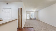 Located at 600 Park Grove Dr in Katy/Houston, TX, this single-story 2-bedroom, 2-bathroom home offers a practical and comfortable layout across a well-utilized floor plan. The living room features vaulted ceilings and plush carpet flooring, with an entry door that welcomes natural light into the space. The kitchen is outfitted with light wood cabinetry, a double-basin sink, granite-look countertops, and wood-look vinyl flooring that extends through the wet areas of the home. Both bedrooms are carpeted and include ceiling fans, windows for natural light, and easy access to closet space. The spacious primary bedroom connects to a dedicated walk-in closet with wire shelving systems, providing ample storage. The two bathrooms each offer distinct configurations: one features a soaking tub and shower combination with white tile surround and overhead cabinetry, while the other is equipped with a walk-in shower featuring a grab bar and built-in open shelving for towels and essentials. A dedicated laundry area with washer/dryer hookups rounds out the functional layout. Throughout the home, neutral tones and clean finishes create a bright, move-in-ready atmosphere.