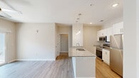 Located at 719 Lantern Walk Dr in Little River, South Carolina, this single-story, one-bedroom, two-bathroom home offers a well-designed layout with contemporary finishes throughout. Light-toned wood-look flooring flows consistently across the living areas, lending a clean and cohesive aesthetic to the space.

The open-concept kitchen serves as a central feature of the home, showcasing white shaker-style cabinetry, granite countertops, and a full suite of stainless steel appliances, including a refrigerator, electric range, and over-the-range microwave. A peninsula with pendant lighting above provides additional prep space and casual seating, while recessed lighting ensures a bright and functional environment.

The spacious primary bedroom features a ceiling fan, a large window with blinds that invites natural light, and neutral wall tones that create a calm, restful atmosphere. A dedicated closet and hallway provide practical storage and circulation throughout the home.

Both bathrooms are finished with granite-topped vanities and white cabinetry. One bathroom includes a tub/shower combination with chrome fixtures and grab bar accessibility features. A utility room rounds out the functional layout.

The overall design is clean and modern, with a neutral palette and quality finishes that make this Little River home both comfortable and move-in ready.