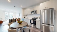 Located on Benton Ave in Nashville's 37204 zip code, this modern one-bedroom, two-bathroom residence offers a thoughtfully designed open-concept layout with contemporary finishes throughout. The kitchen is outfitted with crisp white cabinetry, a classic subway tile backsplash, and a full suite of stainless steel appliances, including a French door refrigerator, electric range, built-in microwave, and dishwasher. Warm hardwood-style flooring runs throughout, seamlessly connecting the kitchen and dining area to the bright living room. The living area is bathed in natural light and opens directly onto a private balcony through full-height sliding glass doors, offering open views of the surrounding community. The bedroom is a comfortable retreat featuring large windows with exterior views, a ceiling fan, and dedicated closet space. Two bathrooms serve the unit, with one showcasing large-format tile flooring, white subway tile tub surround, and sleek matte black fixtures, lending a clean, modern aesthetic. Recessed lighting and neutral wall tones contribute to an airy, cohesive ambiance throughout the entire space, making it an efficient yet stylish home in Nashville.