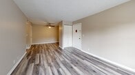 Located at 100 St Francis Ct in Louisville, KY, this one-bedroom, two-bathroom unit offers a well-organized layout across a single floor. Warm neutral tones and clean white trim carry throughout the space, creating a cohesive and inviting atmosphere.

The living room features wood-look plank flooring, a ceiling fan, and a sliding glass door that opens to a private balcony overlooking the tree-lined surroundings — bringing in natural light and outdoor views. The carpeted bedroom is generously sized, offering ample room for furnishings, and includes access to a dedicated closet.

The kitchen is well-appointed with white shaker-style cabinetry, white countertops, a stainless steel sink, and black appliances including a range and dishwasher. A window above the sink allows natural light to fill the space.

Both bathrooms are cleanly finished; one features wood-look flooring, a white vanity with modern hardware, a large mirror, and a tub-shower combo with marble-style tile surround. A hallway and additional closet provide practical storage throughout.

The building exterior is a multi-story brick structure with balconies and on-site parking, set amid mature trees in a residential Louisville neighborhood.