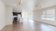 Located at 2131 Lawrence St in Denver's vibrant 80205 neighborhood, this single-floor, three-bedroom, two-bathroom home offers a well-designed layout with modern finishes throughout. The open-concept kitchen and living area serves as the heart of the home, featuring rich dark cabinetry, a white central island, pendant lighting, and a full suite of white appliances including a double oven. Large windows along multiple walls flood the space with natural light, while hardwood-style flooring adds warmth and continuity across the main living areas. The spacious living room benefits from track lighting and roller shades, creating a bright yet versatile environment. The primary bedroom is generously sized, featuring plush carpeting, a ceiling fan, and a large window with views of the surrounding neighborhood. Bedrooms are connected by a carpeted hallway that leads to closets and bathrooms. The bathrooms are finished with dark vanity cabinetry, white countertops, large mirrors, and a soaking tub with tiled surround. Walk-in closets feature wire shelving systems for organized storage. Clean white walls and consistent trim work throughout lend the home a cohesive, contemporary aesthetic.