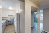 Located on W Linden St in Riverside, CA, this one-bedroom, one-bathroom unit offers a practical and well-organized single-floor layout. The interior features wood-look flooring throughout, neutral warm-gray walls, and textured ceilings that create a consistent, cohesive aesthetic across all rooms.

The kitchen is equipped with white upper cabinetry, a refrigerator, and a range, complemented by a granite-style countertop pass-through that opens to the dining area — an efficient design that enhances the sense of openness and connectivity between spaces. A window above the kitchen sink brings in natural light.

The living room is bright and airy, featuring a large window dressed with vertical blinds that allows ample natural light, a ceiling fan with light fixture, and a wall-mounted air conditioning unit for climate control.

The bedroom is a comfortable size, offering a ceiling fan, a window with outdoor views, a wall-mounted AC unit, and a sliding-door closet for convenient storage. A hallway connects the main living areas to the bedroom and bathroom.

The bathroom features a clean, tiled walk-in shower, a toilet, and a vanity with a white countertop, all finished in neutral tones. The unit's overall design is simple and functional, making it easy to personalize.