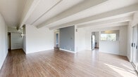Located at 107 W Cheyenne Rd in Colorado Springs, CO, this single-floor unit offers a thoughtfully designed layout with a clean, modern aesthetic throughout. The open living area is defined by striking exposed beam ceilings that add architectural character, while light-toned hardwood-style flooring runs seamlessly across the space. A full wall of sliding glass doors floods the living room with natural light and opens directly onto a private balcony, framing lush, tree-lined views and providing a seamless indoor-outdoor connection. A brick fireplace anchors one side of the living area, adding warmth and a classic touch.

The kitchen is efficiently appointed with gray cabinetry, stainless steel appliances including a refrigerator and range, a white subway tile backsplash, and light countertops. A window above the kitchen brings in additional natural light. The bedroom features a large, three-panel sliding closet offering generous storage, complemented by a wall sconce and cool-toned paint. The bathroom is finished with full white tile walls, a quartz-topped vanity, brushed nickel fixtures, and wood-look tile flooring, creating a clean and contemporary feel throughout.
