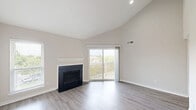Located at 3340 Hampton Point Dr in Silver Spring, MD, this one-bedroom, one-bathroom unit offers a well-designed single-floor layout that makes efficient use of its cozy footprint. The living room is a standout space, boasting soaring vaulted ceilings that lend an open, airy feel, light wood-style flooring, and a classic fireplace with a clean white mantle. A sliding glass door floods the room with natural light and opens to a private balcony with lattice detailing and pleasant neighborhood views. The kitchen is thoughtfully appointed with warm honey-toned cabinetry, granite countertops, and a full suite of stainless steel appliances including a refrigerator, range, microwave, and dishwasher. A breakfast bar provides a casual dining option and connects the kitchen to the living area. The bedroom features plush carpeting, a ceiling fan with light fixture, and its own sliding door access to the balcony, offering both comfort and natural ventilation. A dedicated closet provides ample storage. The bathroom is clean and functional, featuring a full tub-shower combo with tiled surround, granite-topped vanity, and wood-style flooring. A hallway connects all rooms seamlessly, completing this practical and comfortable home.