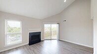 Located at 3340 Hampton Point Dr in Silver Spring, MD, this one-bedroom, one-bathroom unit offers a well-designed single-floor layout that makes efficient use of its cozy footprint. The living room is a standout space, boasting soaring vaulted ceilings that lend an open, airy feel, light wood-style flooring, and a classic fireplace with a clean white mantle. A sliding glass door floods the room with natural light and opens to a private balcony with lattice detailing and pleasant neighborhood views. The kitchen is thoughtfully appointed with warm honey-toned cabinetry, granite countertops, and a full suite of stainless steel appliances including a refrigerator, range, microwave, and dishwasher. A breakfast bar provides a casual dining option and connects the kitchen to the living area. The bedroom features plush carpeting, a ceiling fan with light fixture, and its own sliding door access to the balcony, offering both comfort and natural ventilation. A dedicated closet provides ample storage. The bathroom is clean and functional, featuring a full tub-shower combo with tiled surround, granite-topped vanity, and wood-style flooring. A hallway connects all rooms seamlessly, completing this practical and comfortable home.