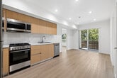 Located at 1616 Venice Blvd in the vibrant Venice neighborhood of Los Angeles, this thoughtfully designed 2-bedroom, 2-bathroom unit offers a clean, modern aesthetic across a single floor. Light wood-style flooring runs throughout, lending warmth and continuity to every room.

The kitchen is a standout feature, outfitted with warm wood cabinetry extending to the ceiling, stainless steel appliances including a refrigerator, gas range, and dishwasher, a white quartz countertop, and a subway tile backsplash. Recessed lighting illuminates the space efficiently.

Both bedrooms are bright and functional. The primary bedroom features mirrored sliding closet doors that enhance the sense of space, while the second bedroom benefits from a large window framing lush green tree canopy views, filling the room with natural light.

The two bathrooms share a cohesive design language, each featuring large-format marble-look tile surrounds on the tub-shower combinations, wood-toned vanities with white basins, and light wood flooring. Glass sliding shower doors add a refined, contemporary touch.

The unit also includes a louvered utility closet near the entry, a wall-mounted thermostat for climate control, and a clean, minimal entryway. The overall ambiance is bright, modern, and move-in ready, well-suited for the laid-back yet stylish Venice lifestyle.
