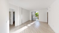 This contemporary apartment in Boca Raton, FL, offers 1050 square feet of thoughtfully designed living space. The single-story layout comprises three bedrooms, including a spacious 170 sq ft primary bedroom, and two well-appointed bathrooms. The interior showcases a bright, open-concept design with a cohesive aesthetic throughout.

Light wood-look flooring unifies the space, complementing the crisp white walls and ceilings. The kitchen is a highlight, featuring sleek white cabinetry, stainless steel appliances, and a central island, perfect for casual dining or food preparation. Track lighting and pendant fixtures provide both ambient and task lighting.

The bathrooms boast modern fixtures, with one featuring a glass-enclosed shower and another offering a shower/tub combination. Large windows in the bedrooms and living areas flood the space with natural light, while horizontal blinds offer privacy control. A sliding glass door leads to a balcony, providing a connection to the outdoors and views of tropical landscaping.

Storage is ample, with closets in the bedrooms and additional built-in shelving. The apartment's neutral color palette and clean lines create a canvas for personal style, making it suitable for a variety of tastes and lifestyles. This well-designed space combines functionality with contemporary flair, offering a comfortable and stylish urban living experience in Boca Raton.
