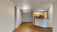 Located at 1904 Parable Way in Cary, NC, this single-floor residence offers a well-planned layout designed for comfortable everyday living. The open-concept living and dining area is finished with warm hardwood-style flooring, crown molding, and neutral-toned walls, creating a bright and cohesive atmosphere. Track lighting accents the dining space, while the adjoining kitchen is accessible via a peninsula with granite-style countertops that doubles as a breakfast bar.

The galley kitchen is well-appointed with warm wood cabinetry, granite-style countertops, a mosaic tile backsplash, and stainless steel appliances including a range and microwave. A dedicated in-unit laundry area is conveniently located directly off the kitchen and includes a full-size washer and dryer with overhead wire shelving for storage.

The bedrooms feature plush carpeting, ceiling fans with light fixtures, and generous closet space. One bedroom includes a window overlooking the surrounding neighborhood, offering natural light. The primary bathroom is equipped with a dual-sink vanity, wood cabinetry, and a tub-shower combination, while the secondary bathroom features a single vanity and a tub-shower unit. Hardwood-style flooring runs through the main living areas, contributing to a clean, unified aesthetic throughout.