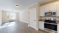Located at 189 Paddlers Pt in Matamoras, PA, this well-appointed single-floor unit offers a clean, modern aesthetic with thoughtful finishes throughout. The open-concept living area is bright and welcoming, featuring warm neutral-toned walls, crown molding, and durable wood-look vinyl plank flooring that flows seamlessly through the space. Natural light pours in through large windows fitted with horizontal blinds, offering pleasant views of the surrounding greenery.

The kitchen is well-equipped with white shaker-style cabinetry, granite countertops, and a full suite of stainless steel appliances including a refrigerator with ice and water dispenser, electric range, built-in microwave, and dishwasher. The layout provides ample counter and storage space, making it functional for everyday use.

The unit includes two bathrooms, both finished with white vanity cabinetry, granite countertops, large mirrors, and wood-look vinyl flooring. One bathroom features a tub-shower combination with glass sliding doors, while the other offers a more spacious vanity area with generous storage. Each bathroom is accented with stylish oil-rubbed bronze fixtures and well-positioned lighting.

The bedrooms are generously sized, each featuring ceiling fans and windows that invite natural light. The overall ambiance of this unit is clean, neutral, and move-in ready.