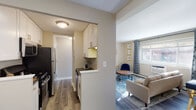 Located at 5100 N Sheridan Road in Chicago's Edgewater neighborhood, this single-floor residence offers a thoughtfully arranged layout connecting key living areas with a cohesive, contemporary aesthetic. Throughout the unit, wood-style flooring ties the spaces together, complemented by neutral wall tones and modern finishes.

The galley-style kitchen is efficiently designed, featuring white cabinetry with brushed nickel hardware, dark countertops, a gold undermount sink, subway tile backsplash, and a full suite of stainless steel appliances including a gas range, built-in microwave, dishwasher, and refrigerator. The kitchen opens toward a dedicated dining area, which comfortably accommodates a full-sized table and chairs beneath contemporary wall art.

The living room receives natural light through a large street-facing window dressed with patterned drapes, creating a welcoming atmosphere. A wall-unit air conditioner and baseboard heating provide year-round comfort.

The bedroom is a calm, well-proportioned retreat with wall-mounted shelving and ample natural light. The full bathroom features white subway tile surrounding the tub and shower, a white vanity with dark countertop, and a large mirror. A louvered closet door in the hallway provides additional storage access throughout this well-appointed urban residence.