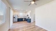 Located at 2800 N Bonnie Brae St in Denton, TX, this well-designed two-bedroom, one-bathroom home offers a thoughtfully arranged single-floor layout with contemporary finishes throughout. Light wood-look flooring runs continuously across all rooms, creating a cohesive and airy feel.

The kitchen is a standout feature, boasting striking two-tone cabinetry with navy lower cabinets and crisp white uppers, complemented by a classic white subway tile backsplash and light granite-style countertops. Stainless steel appliances, including a French door refrigerator, range, microwave, and dishwasher, complete the modern aesthetic. A sliding glass door in the kitchen area floods the space with natural light and provides outdoor access.

The open living area flows naturally from the kitchen and is fitted with a ceiling fan. A bright hallway connects the bedrooms, both of which feature ceiling fans, light-filled windows with blinds, and the same warm wood-look flooring. The primary bedroom offers dual windows for ample natural light.

The bathroom is finished with a navy vanity, granite countertop, undermount sink, brushed nickel fixtures, and large windows that brighten the space. Clean white walls and modern hardware carry the home's cohesive, contemporary design from room to room.