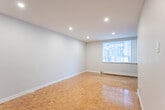 Located at 2202 Weston Rd, Unit 205, in Toronto's Weston neighbourhood, this one-bedroom, one-bathroom unit offers a functional and well-appointed layout across a single floor. Warm-toned parquet flooring runs throughout the main living areas and bedroom, lending a classic character to the space.

The combined living and dining area is bright and open, featuring large windows with vertical blinds that invite natural light, complemented by recessed pot lighting and a baseboard heating unit. The space offers a comfortable, versatile footprint suitable for various furniture arrangements.

The galley-style kitchen is efficiently designed with rich, dark wood cabinetry lining both walls, light stone countertops, a stainless steel sink, and stainless steel appliances including a range and refrigerator. Light ceramic tile flooring completes the kitchen's clean, practical aesthetic.

The bedroom provides a comfortable retreat with the same warm parquet flooring, soft neutral walls, and a double sliding-door closet offering ample storage.

The bathroom is finished with crisp white rectangular subway-style wall tiles surrounding a full soaker tub and shower, paired with a dark vanity cabinet, creating a clean, modern contrast. The overall ambiance of the unit is neutral, bright, and move-in ready.