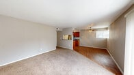 This 2-bedroom, 2-bathroom single-floor residence offers a functional and comfortable layout designed for everyday living. The open-concept living and dining area is anchored by wood-look flooring in the dining zone, transitioning to plush carpet in the living area. A ceiling fan with light kit adds both comfort and ambiance, while a large sliding glass door with vertical blinds fills the space with natural light and provides outdoor access. The galley-style kitchen features warm wood cabinetry, stainless steel appliances including a refrigerator and range, a double-basin sink, and ample counter space — all set over easy-care wood-look flooring. A pass-through window connects the kitchen to the main living area, enhancing the open feel. The spacious primary bedroom includes plush carpet, a ceiling fan, a closet, and a private en-suite bathroom with a bathtub/shower combo. The second bedroom is equally well-sized with soft carpet and a closet. Both bathrooms are finished with warm wood vanities and gray countertops. A hallway connects the bedrooms and provides convenient access throughout the unit, completing this thoughtfully arranged floor plan.