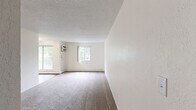 Located at 3675 Highland Ave in White Bear Lake, Minnesota, this 2-bedroom, 1-bathroom unit offers a practical and comfortable single-floor layout. The galley-style kitchen features warm wood-look vinyl flooring, white cabinetry, a gas range, a stainless steel refrigerator, and a double sink with a light granite-style countertop — with direct sightlines to the bathroom for convenient accessibility. The living area is generously sized, finished with plush carpet and a textured ceiling, and receives natural light through a sliding window framing lush greenery outside. Both bedrooms are carpeted and equipped with ceiling fans and baseboard heating. The spacious primary bedroom includes dual sliding closet doors for ample storage, a large window with outdoor tree views, and a ceiling fan with light fixture. The second bedroom, also well-sized, features a ceiling fan and access through a warm wood-toned interior door. The full bathroom is finished with white tile wainscoting, tile flooring, a tub/shower combo, and a vanity with storage. Throughout the unit, neutral tones, plush carpet, and consistent finishes create a clean, move-in-ready atmosphere.