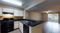 This single-story unit located in Bradenton, Florida offers a practical and cohesive layout designed for comfortable everyday living. Wood-look flooring runs consistently throughout the space, lending a unified and warm aesthetic to every room.

The kitchen is equipped with white cabinetry, dark granite-style countertops, and black appliances including a gas range with overhead ventilation, a dishwasher, and a double-basin sink. A peninsula counter connects the kitchen to the adjacent living area, creating an open flow between the two spaces. The living room is generously sized, featuring a ceiling fan with light fixture and a textured ceiling. A sliding glass door provides direct access to the outdoors and frames views of surrounding greenery, bringing in natural light.

The bedrooms continue the wood-look flooring and are finished with neutral-toned walls, ceiling fans, and vertical blinds covering the windows. The bathroom includes a tub-shower combination, a toilet, and a vanity with a dark countertop, maintaining the consistent finishes found throughout the unit. A hallway connects the main living areas to the private rooms, contributing to an efficient and straightforward floor plan throughout this Bradenton residence.