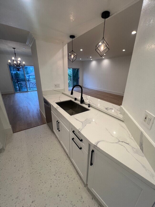 New counters and cabinets. Oversized sink. Bar style opening into the family room. - 1722 Malcolm Ave