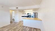 Located at 699 S Tucson Blvd in Tucson, Arizona, this single-floor, two-bedroom, one-bathroom unit offers a thoughtfully designed layout that maximizes its compact footprint. Wood-look flooring flows consistently throughout the entire space, providing a cohesive and low-maintenance aesthetic.

The kitchen serves as the centerpiece of the home, featuring white shaker-style cabinetry, dark granite countertops, and a full suite of stainless steel appliances including a range, microwave, and refrigerator. A peninsula with a butcher block countertop extends into the living area, offering additional prep space and a natural division between the kitchen and the rest of the unit. An entry door with a window provides access to natural light near the dining area.

The primary bedroom is a well-proportioned private retreat with a window fitted with blinds, allowing for natural light and privacy. A dedicated walk-in closet with a hanging rod provides ample storage. The second bedroom is equally clean and bright, finished with the same wood-look flooring and white walls.

The bathroom is finished with white tile surrounding the tub-shower combination, white cabinetry with dark countertops, and matching wood-look flooring. Clean lines and a neutral palette throughout the unit create a bright, move-in-ready atmosphere.