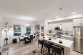 Located in the northwest Edmonton community of Laubman Street, this well-designed 2-bedroom, 2-bathroom unit offers a thoughtfully arranged single-level floor plan. Light-toned luxury vinyl plank flooring flows throughout, complementing the crisp white walls and modern finishes seen across every room.

The open-concept living, dining, and kitchen area forms the heart of the unit. The kitchen is outfitted with two-tone cabinetry — white uppers paired with warm wood-finish lowers — stainless steel appliances including a built-in microwave and electric range, a subway tile backsplash, and a central island with white quartz countertops and bar seating. Pendant lighting and recessed pot lights illuminate the space. The dining area accommodates a full-sized table and benefits from large windows overlooking the patio. The living room features generous windows that bring in natural light.

A well-lit hallway connects the private quarters, where two bedrooms each include closets. The primary bedroom offers a double-door closet and direct access to the hallway. Both bathrooms are clean and functional, with one featuring a full soaker tub and tiled surround. In-suite laundry adds convenience. The private patio, framed by stone exterior cladding, provides outdoor access and neighbourhood views.