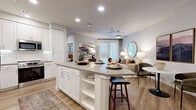Located at 2332 N 7th St in Phoenix, AZ, this thoughtfully designed one-bedroom, one-bathroom residence offers a cohesive open-concept layout finished with light wood-style flooring and a neutral color palette throughout. The kitchen is a standout feature, showcasing white shaker cabinetry, subway tile backsplash, quartz countertops, stainless steel appliances, and a peninsula island with bar seating — ideal for both cooking and casual dining. The kitchen flows seamlessly into the living room, which is filled with natural light from full-height French doors that lead to a private balcony. The bedroom is a comfortable retreat with a ceiling fan, large windows with blinds, and direct access to a well-sized walk-in closet featuring multi-level shelving and hanging rods. The bathroom is finished with white shaker vanity cabinetry, quartz countertops, a large mirror, and a tiled tub-shower combination. A dedicated laundry area with shelving provides convenient in-unit washing. Recessed lighting throughout and a clean, modern aesthetic make this residence a functional and stylish home in the heart of Phoenix.