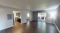 Located at 2000 W Algonquin Rd in Mount Prospect, Illinois, this single-floor unit offers a well-designed layout with a cohesive, modern aesthetic throughout. The open living and dining area is finished with rich, dark hardwood-style flooring and neutral gray walls, creating a clean and contemporary atmosphere. A large sliding glass door floods the space with natural light and provides direct access to an outdoor balcony area, offering pleasant exterior views. The kitchen is thoughtfully appointed with dark espresso-toned cabinetry, white quartz-style countertops, a mosaic tile backsplash, and stainless steel appliances, including a refrigerator, range, and built-in microwave. The galley-style layout maximizes counter and storage space efficiently. The bedrooms feature plush carpeting and generous closet space. The primary bedroom includes an attached bathroom and a wide closet with built-in shelving. Additional bedrooms are well-proportioned, with one featuring a ceiling fan and hardwood-style flooring, and another with soft carpet and a bright window. The bathroom includes a full tub-and-shower combination with white tile surround and brushed nickel fixtures. Throughout the unit, clean white trim and neutral tones provide a versatile, move-in ready environment.