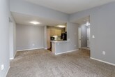 Located at 3933 NW 85th Terrace in Kansas City, MO, this single-floor residence offers a well-organized layout with a variety of functional living spaces. The open-concept living area is anchored by plush carpeting and neutral gray walls, with a vaulted ceiling that lends a sense of added volume. A sliding glass door provides access to an outdoor balcony, allowing natural light to filter into the space. The kitchen is designed in a galley style, featuring light wood cabinetry, white countertops, wood-look flooring, and black appliances including a refrigerator, dishwasher, electric range, and built-in microwave. A peninsula counter connects the kitchen to the living area, enhancing functionality and flow.

The bedrooms are carpeted and finished with gray walls and ceiling fans. The primary bedroom includes a spacious walk-in closet, while additional bedrooms offer standard closets with built-in shelving. The primary bathroom features a long vanity with light wood cabinetry, a white countertop, a wall mirror, and a glass-enclosed shower stall with wood-look flooring. A secondary bathroom includes a single-sink vanity and a full tub-shower combination, also with wood-look flooring. The overall aesthetic is clean, neutral, and move-in ready.