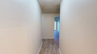 Located at 1240 East Avenue S in Palmdale, CA, this single-floor, 2-bedroom, 1-bathroom residence offers a practical and well-organized layout. Light-toned wood-look flooring runs throughout the entire unit, creating a cohesive and clean aesthetic across all rooms.

The living room is a comfortable, open space featuring a ceiling fan, a wall-mounted HVAC unit, and large sliding glass doors fitted with vertical blinds that provide direct access to an outdoor patio with views of the surrounding complex. A peninsula counter connects the living area to the adjacent kitchen, adding a functional pass-through element.

The kitchen is designed for efficiency, featuring white cabinetry with ample upper and lower storage, granite-style countertops, a double-basin stainless steel sink, a dishwasher, and a white electric range with an overhead exhaust.

Both bedrooms are bright and well-proportioned. The primary bedroom offers generous space, while the second bedroom includes a built-in closet with sliding doors. Natural light enters both rooms through windows dressed with vertical blinds. Textured ceilings are present throughout the unit.

The bathroom is clean and straightforward, offering a shower-tub combination, a toilet, and a vanity with cabinet storage. Two hallways connect the rooms, providing a logical and easy-to-navigate flow throughout the residence.
