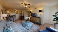 This well-appointed residence in Tuscaloosa, Alabama offers three bedrooms and three bathrooms across a single floor, providing a comfortable and functional layout. The open-concept living room serves as the heart of the home, featuring plush carpet, a ceiling fan with integrated lighting, large windows that invite natural light, and ample space for relaxed gathering. A standout wall provides an ideal backdrop for artwork, adding to the room's welcoming ambiance.

The kitchen is efficiently designed with white cabinetry, dark countertops, tile flooring, and a full suite of appliances including a refrigerator, dishwasher, and range. A breakfast bar with seating connects the kitchen to a dedicated dining area, creating a seamless flow for everyday living and entertaining.

Each of the three bedrooms is fitted with soft carpet, a ceiling fan, and its own closet. The primary bedroom is generously sized with vaulted ceiling accents and a window that fills the room with natural light. The additional bedrooms offer comfortable dimensions suitable for guests or a home office.

All three bathrooms feature tiled flooring and tub/shower combinations with sliding glass enclosures and vanities with white cabinetry. A hallway connects the private quarters, maintaining a clear separation between the living and sleeping areas throughout this thoughtfully designed home.
