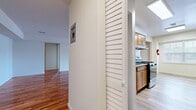 This well-appointed one-bedroom, one-bathroom residence at 25 Cinder Rd in Edison, NJ offers a thoughtfully designed single-floor layout with warm hardwood flooring flowing throughout the main living areas. The open living room is generously sized, bathed in natural light through large sliding glass doors that open to the outdoors, creating an airy and inviting atmosphere. The galley-style kitchen is efficiently laid out with warm honey-toned wood cabinetry, granite countertops, a subway tile backsplash, and a full suite of stainless steel appliances including a gas range, dishwasher, and refrigerator — all illuminated by overhead lighting and a window at the end of the corridor. A louvered door separates the kitchen from the entryway hallway, which also features a wall-mounted thermostat panel for convenient climate control. The spacious primary bedroom features polished hardwood floors, a large window for natural light, and a sliding-door closet with built-in shelving for ample storage. The bathroom is cleanly finished with tile flooring, a granite-topped wood vanity, and a sleek tub-shower combination enclosed by sliding glass doors with marble-style tile surrounds.