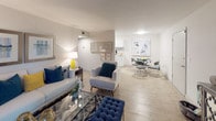 This single-floor residence offers a cohesive, modern aesthetic carried consistently throughout each room. The living area serves as the heart of the home, featuring wood-style flooring, neutral walls, and a sliding glass door fitted with vertical blinds that allows natural light to fill the space. The open layout connects the living area to a dedicated dining space, creating a seamless flow ideal for everyday living and entertaining.

The kitchen is well-equipped with white shaker-style cabinetry, granite-look countertops, a subway tile backsplash, a stainless steel sink with a brushed nickel faucet, and stainless steel appliances. Wood-style flooring continues underfoot, maintaining visual continuity with the adjacent living spaces.

Both bedrooms are carpeted and include ceiling fans with integrated lighting. Each room offers a comfortable footprint with vertical blind-covered windows that provide natural light and privacy. The rooms share a clean, neutral palette that complements flexible furnishing arrangements.

The full bathroom features a tub-shower combination with white subway tile surround and a built-in niche, a white vanity with granite-style countertop, and wood-style flooring. The overall ambiance of the residence is modern, clean, and move-in ready.