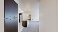 This two-bedroom, two-bathroom apartment in Portland, Oregon offers a thoughtfully laid-out single-floor plan with a clean, contemporary aesthetic throughout. The kitchen is a standout feature, equipped with dark espresso cabinetry extending to the ceiling, granite-style countertops, stainless steel appliances including a refrigerator, range, and microwave, and a tile backsplash that ties the design together. Skylights and recessed lighting keep the space bright and functional.

The spacious primary bedroom benefits from dual windows framing lush greenery views, filling the room with natural light and a sense of calm. The second bedroom also features a window with garden views and soft carpeted flooring, consistent throughout both bedrooms and the living area. Each bathroom is finished with dark-cabinetry vanities, granite-topped counters, large mirrors, and tub-shower combinations with neutral tile flooring, offering a cohesive and practical design.

The open floor plan connects the kitchen and living areas seamlessly, as seen in the dollhouse view, creating an efficient and comfortable flow. A dedicated closet and in-unit utility elements add to the overall functionality of this well-appointed Portland residence.