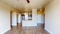 Located at 9331 Westridge Blvd in Frisco, TX, this well-appointed 2-bedroom, 2-bathroom residence offers a thoughtfully designed single-level layout. The open-concept living and kitchen area serves as the heart of the home, featuring rich hardwood-style flooring, warm neutral tones, and a ceiling fan overhead. The kitchen is equipped with stainless steel appliances, dark espresso cabinetry, granite countertops, track lighting, and a peninsula with pendant lights and a built-in sink — ideal for both meal prep and casual dining. The living room opens to a private balcony through a glass-panel door, allowing natural light to fill the space and providing outdoor views. Both bedrooms are carpeted for comfort and include ceiling fans and windows with blinds. The spacious primary bedroom benefits from its own dedicated bathroom, which features a dual-sink granite vanity with dark cabinetry, a full soaking tub with tiled surround, and hardwood-style flooring. The second bathroom mirrors the same quality finishes. Additional highlights include a dedicated laundry area, an entrance foyer, a hallway, and three closets offering generous storage throughout.