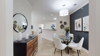 This single-story residence offers a thoughtfully designed open-concept layout with a seamless flow between its primary living areas. Light wood-look flooring extends throughout, providing a warm and cohesive foundation for each room.

The dining area makes a bold visual statement with a dark accent wall, pendant lighting, and direct sightlines into the adjacent kitchen and living spaces. The kitchen is well-equipped with white shaker cabinetry, granite-look countertops, stainless steel appliances, and a pass-through that maintains connectivity to the rest of the home.

The living room is bright and inviting, featuring a soft blue accent wall, crown molding, and a large window that draws in generous natural light. The bedroom is a quiet, comfortable retreat with multiple windows offering outdoor views, light wood-look flooring, and a spacious walk-in closet outfitted with wire shelving for organized storage.

The bathroom is notably spacious, featuring a granite-topped vanity with ample counter space, a tub-shower combination, and a window that introduces natural light. Throughout the home, crown molding and recessed lighting contribute to a polished, finished aesthetic.