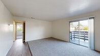 Located at 2751 Monument Blvd in Concord, CA, this single-floor unit offers three bedrooms and one bathroom within a compact, efficiently arranged floor plan. The living area features soft carpet flooring and a sliding glass door that opens to a balcony, allowing natural light to fill the space and providing outdoor views of the surrounding neighborhood. The transition between the living area and kitchen is marked by a shift to wood-style vinyl flooring, which continues through the galley-style kitchen. The kitchen is outfitted with white cabinetry, light granite-style countertops, an electric range, refrigerator, and under-cabinet ventilation, making efficient use of the narrow layout. The full bathroom includes a white vanity with a matching countertop, a combined tub and shower enclosure, and wood-style flooring. The three bedrooms are carpeted and finished in neutral tones, each benefiting from natural light through windows. The primary bedroom is notably spacious, featuring a sliding-door closet with a built-in hanging rod. The remaining bedrooms are well-proportioned and share access to a central hallway. Textured ceilings are present throughout, and the overall palette of whites and neutrals gives the unit a clean, move-in-ready appearance.