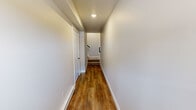 This contemporary three-story townhome in Cedar Rapids, Iowa, offers a well-designed layout across three levels, delivering a comfortable and functional living experience. The main living floor features an open-concept kitchen and living area finished with warm wood-look luxury vinyl plank flooring throughout. The kitchen is equipped with stainless steel appliances, including a refrigerator, range, and microwave, complemented by crisp white shaker cabinetry, a large island with an undermount sink, and clean white countertops. Recessed lighting brightens the space, giving it a modern, polished feel. A private balcony off the main level offers views of the surrounding townhome community. The upper floor houses the bedrooms, including a generously sized primary bedroom with plush carpeting, a ceiling fan, and multiple windows that bring in natural light. Additional bedrooms feature the same neutral palette and wood-look flooring with ample closet space. Three well-appointed bathrooms include white vanities, large mirrors, modern light fixtures, and walk-in showers. Connecting the floors are carpeted staircases with clean railings, and hallways finished in the same consistent, neutral tones that unify the home's cohesive aesthetic.