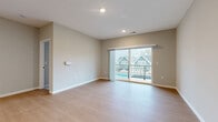 Located at 7181 N Hamilton Rd in Columbus, Ohio, this well-appointed 2-bedroom, 2-bathroom residence offers a thoughtfully designed single-floor layout with a clean, contemporary aesthetic. The open-concept kitchen and living area serves as the heart of the home, anchored by a central island with a granite-style countertop, dark cabinetry with matte black hardware, and a full suite of stainless steel appliances including a refrigerator, range, and microwave. Light wood-look flooring runs throughout the main living area, complementing the neutral gray and beige tones of the walls. The spacious living room is bathed in natural light and opens directly onto a private balcony through sliding glass doors, offering views of the surrounding community. Both bedrooms feature plush carpet flooring and large windows that bring in ample daylight. The bathrooms are finished with granite-style countertops, gray cabinetry, undermount sinks, and matte black fixtures; one bathroom includes a walk-in shower with sleek black-framed glass doors. Additional highlights include four closets for generous storage, a dedicated laundry area, and a utility room. The overall ambiance is modern, bright, and move-in ready.