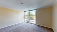 Located at 20881 Wilbeam Ave in Castro Valley, California, this single-floor residence offers a well-organized layout with a comfortable, functional design throughout. The living area is a standout feature, characterized by large floor-to-ceiling windows that flood the carpeted space with abundant natural light and provide pleasant views of the surrounding greenery and neighborhood. Crown molding details add a refined touch to the room's clean, neutral walls.

The kitchen is efficiently designed with white cabinetry providing ample storage, granite-style countertops, and tile flooring. It is equipped with a gas range, refrigerator, and dishwasher, and features a window above the sink that brings in additional natural light. The kitchen opens toward a hallway that connects the living and private areas of the home seamlessly.

The bedrooms are carpeted and finished with the same warm, neutral tones found throughout the residence. Each room is equipped with a ceiling fan and a window, ensuring ventilation and natural light. Crown molding accents carry through these spaces, maintaining a consistent aesthetic.

The bathroom includes a combined tub and shower enclosed with sliding glass doors, a white vanity with granite-style countertops, and tile flooring that complements the overall design palette. The layout of this residence offers a practical and cohesive living environment in the heart of Castro Valley.