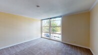 Located at 20881 Wilbeam Ave in Castro Valley, California, this single-floor residence offers a well-organized layout with a comfortable, functional design throughout. The living area is a standout feature, characterized by large floor-to-ceiling windows that flood the carpeted space with abundant natural light and provide pleasant views of the surrounding greenery and neighborhood. Crown molding details add a refined touch to the room's clean, neutral walls.

The kitchen is efficiently designed with white cabinetry providing ample storage, granite-style countertops, and tile flooring. It is equipped with a gas range, refrigerator, and dishwasher, and features a window above the sink that brings in additional natural light. The kitchen opens toward a hallway that connects the living and private areas of the home seamlessly.

The bedrooms are carpeted and finished with the same warm, neutral tones found throughout the residence. Each room is equipped with a ceiling fan and a window, ensuring ventilation and natural light. Crown molding accents carry through these spaces, maintaining a consistent aesthetic.

The bathroom includes a combined tub and shower enclosed with sliding glass doors, a white vanity with granite-style countertops, and tile flooring that complements the overall design palette. The layout of this residence offers a practical and cohesive living environment in the heart of Castro Valley.